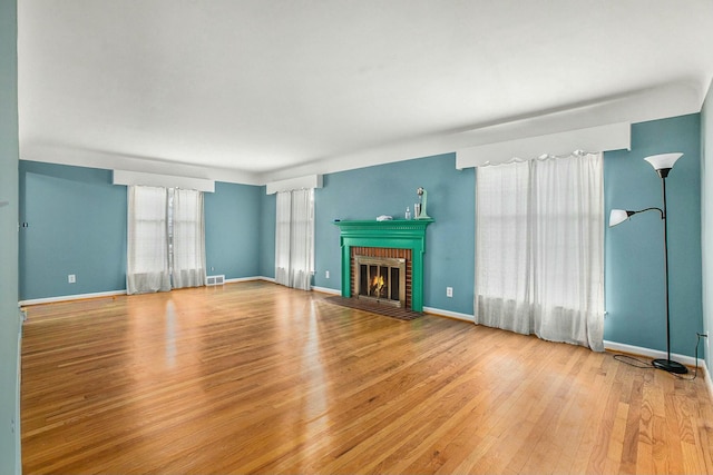 unfurnished living room with wood-type flooring and a fireplace