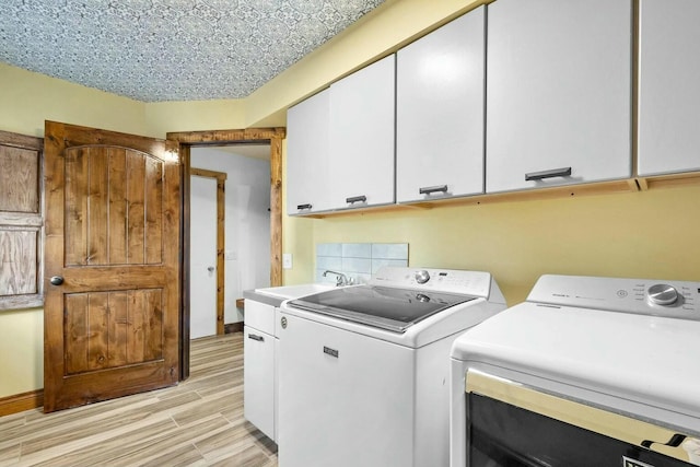 laundry room with independent washer and dryer, sink, light hardwood / wood-style flooring, and cabinets