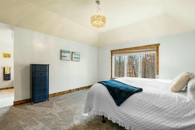 carpeted bedroom featuring an inviting chandelier and vaulted ceiling