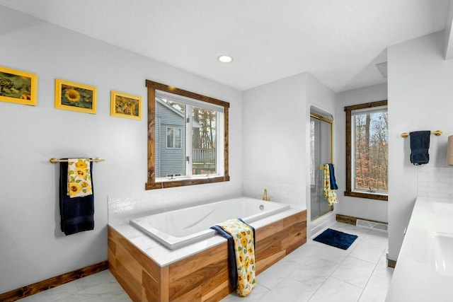 bathroom with vanity, plenty of natural light, and separate shower and tub