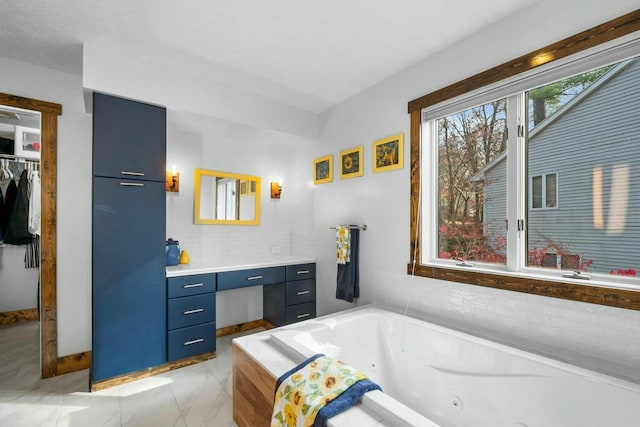 bathroom with tiled tub and vanity