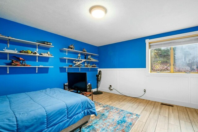 bedroom with hardwood / wood-style flooring and a textured ceiling