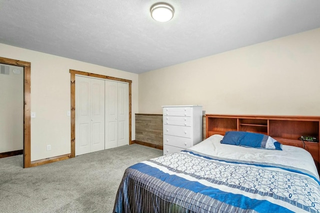 bedroom with a closet, a textured ceiling, and carpet flooring