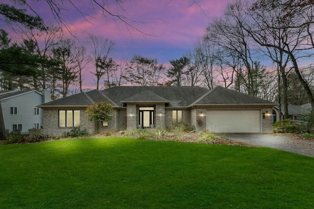 view of front of home with a garage and a yard