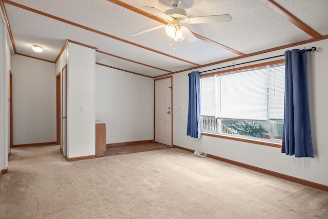 carpeted empty room with crown molding, ceiling fan, and a textured ceiling