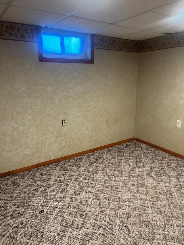 basement featuring a drop ceiling and carpet floors