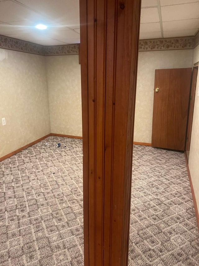 unfurnished room with a paneled ceiling and light colored carpet