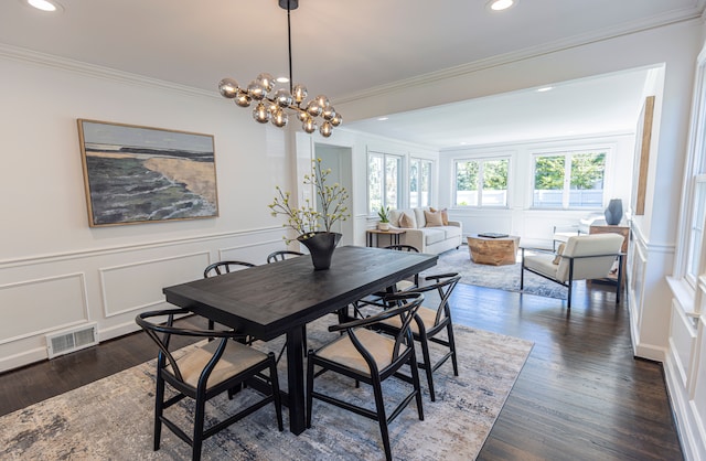 dining space featuring an inviting chandelier, dark wood-type flooring, and ornamental molding