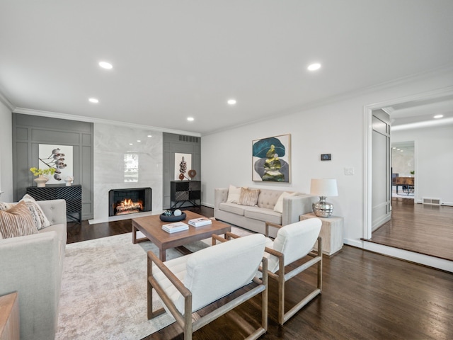 living room with crown molding, a high end fireplace, and dark hardwood / wood-style floors