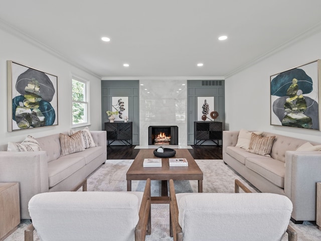 living room with crown molding, wood-type flooring, and a premium fireplace