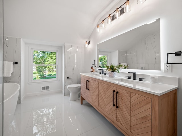 bathroom featuring vanity, vaulted ceiling, a tub, and toilet