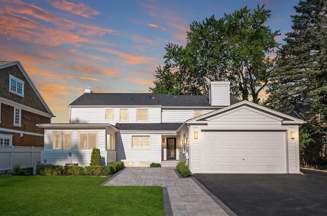 view of front of home featuring a garage and a lawn