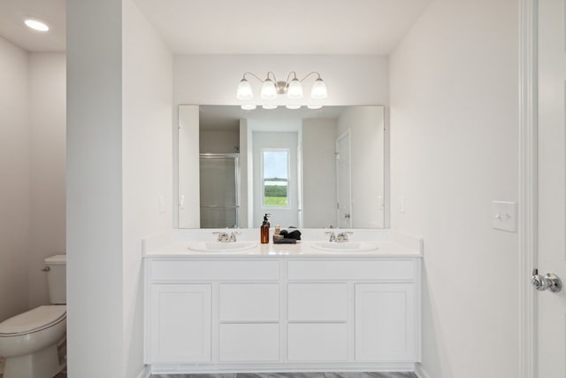 bathroom with vanity, a shower with shower door, and toilet