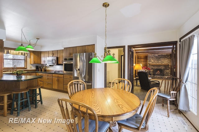 dining area featuring sink and a brick fireplace