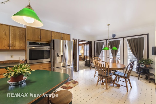 kitchen with decorative light fixtures, a healthy amount of sunlight, and appliances with stainless steel finishes