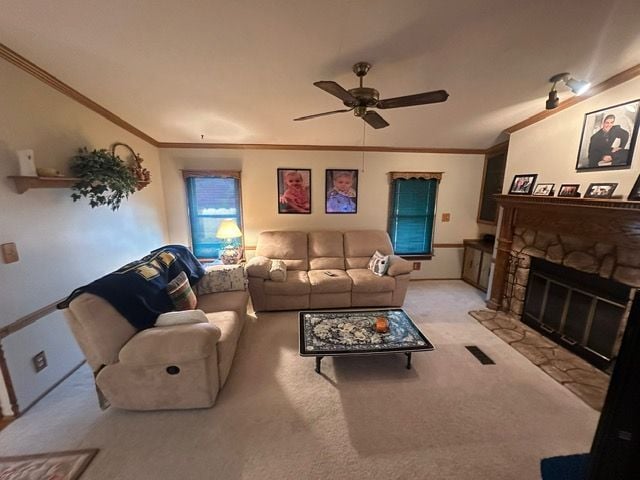 living room with crown molding, light colored carpet, a fireplace, and ceiling fan