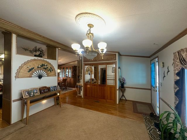 carpeted dining room featuring a notable chandelier and ornamental molding