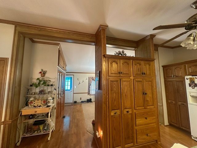 hall with light hardwood / wood-style flooring and ornamental molding