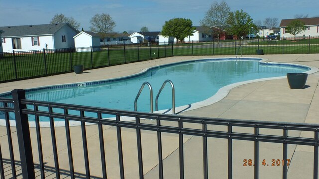 view of pool featuring a yard and a patio