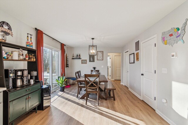 177 E Lowry, Brooklyn, MI 49230 - dining area featuring light wood-style floors, baseboards, and a chandelier