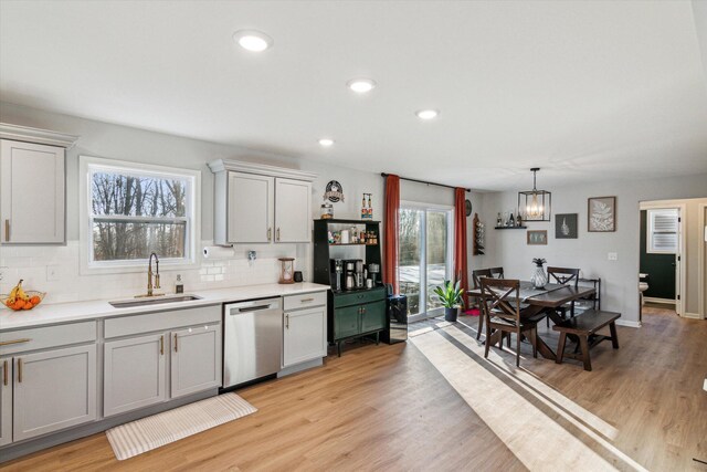 177 E Lowry, Brooklyn, MI 49230 - kitchen featuring stainless steel dishwasher, a sink, tasteful backsplash, light countertops, and a chandelier