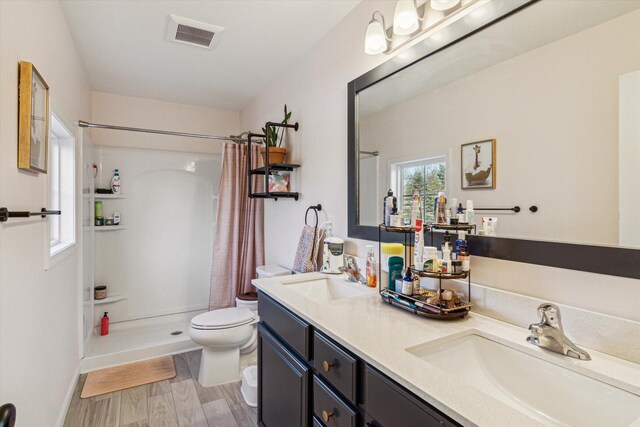 177 E Lowry, Brooklyn, MI 49230 - bathroom featuring toilet, a stall shower, double vanity, wood finished floors, and baseboards