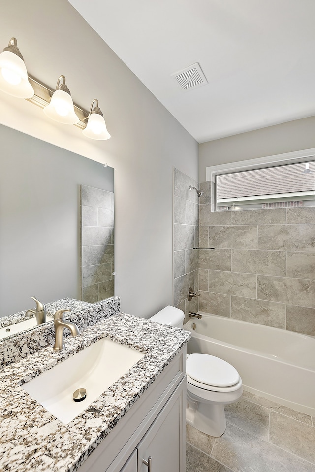 full bathroom with tiled shower / bath, vanity, and toilet