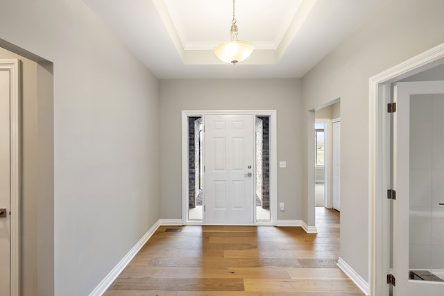 entrance foyer featuring a tray ceiling and light wood-type flooring