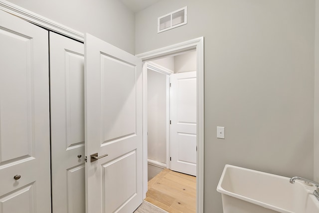 hall with sink and light hardwood / wood-style floors