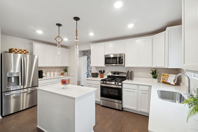 kitchen featuring white cabinetry, appliances with stainless steel finishes, sink, and pendant lighting