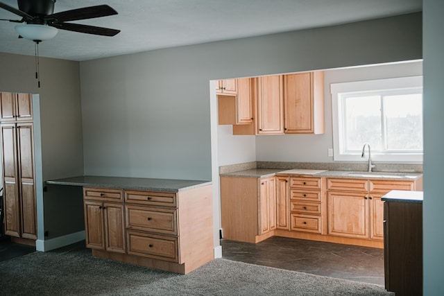 kitchen featuring a sink, ceiling fan, and dark carpet