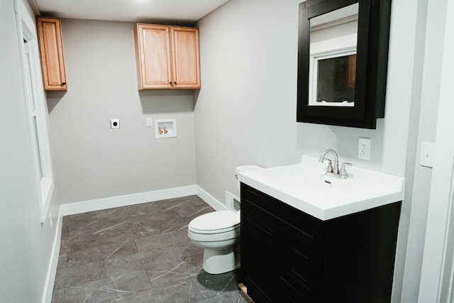 bathroom with baseboards, toilet, and vanity