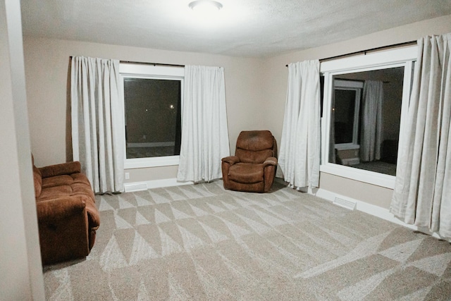 living area with visible vents and carpet floors