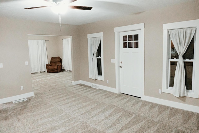 unfurnished room featuring visible vents, baseboards, carpet, and a ceiling fan