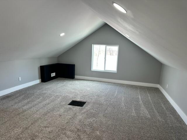 bonus room with lofted ceiling, baseboards, and carpet floors