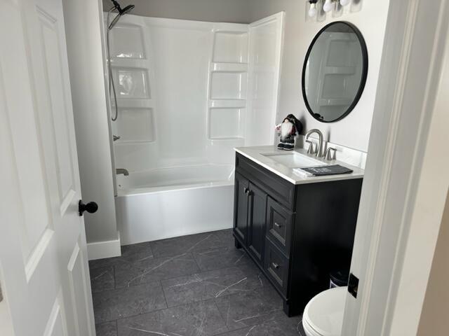 full bathroom featuring vanity, toilet, and  shower combination