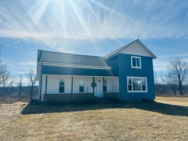 view of front of property featuring covered porch and a front lawn