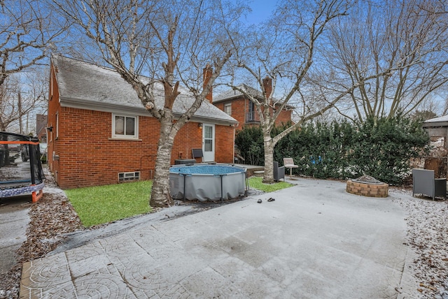 view of patio / terrace featuring a trampoline and a fire pit