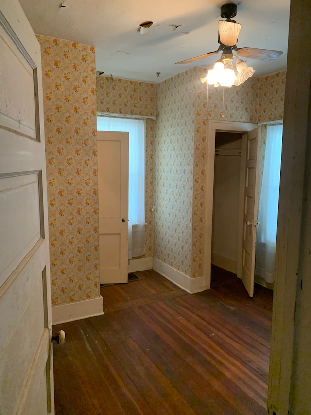 unfurnished bedroom featuring ceiling fan, dark hardwood / wood-style floors, and a closet