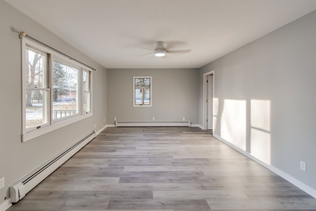 unfurnished room featuring ceiling fan, light hardwood / wood-style floors, and a baseboard heating unit