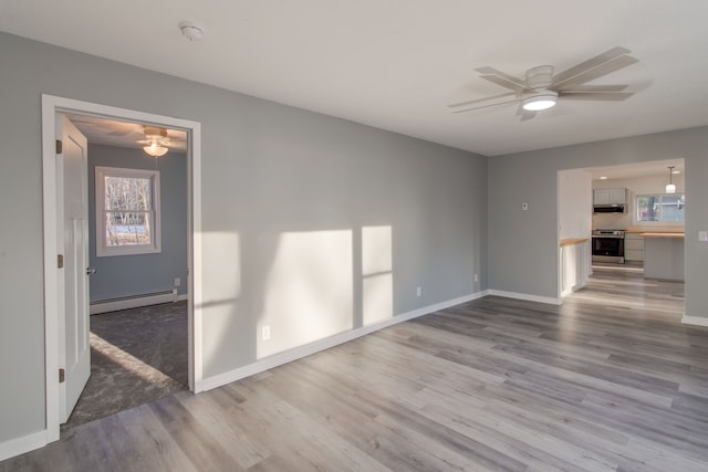 unfurnished living room with a baseboard radiator, ceiling fan, and light hardwood / wood-style flooring