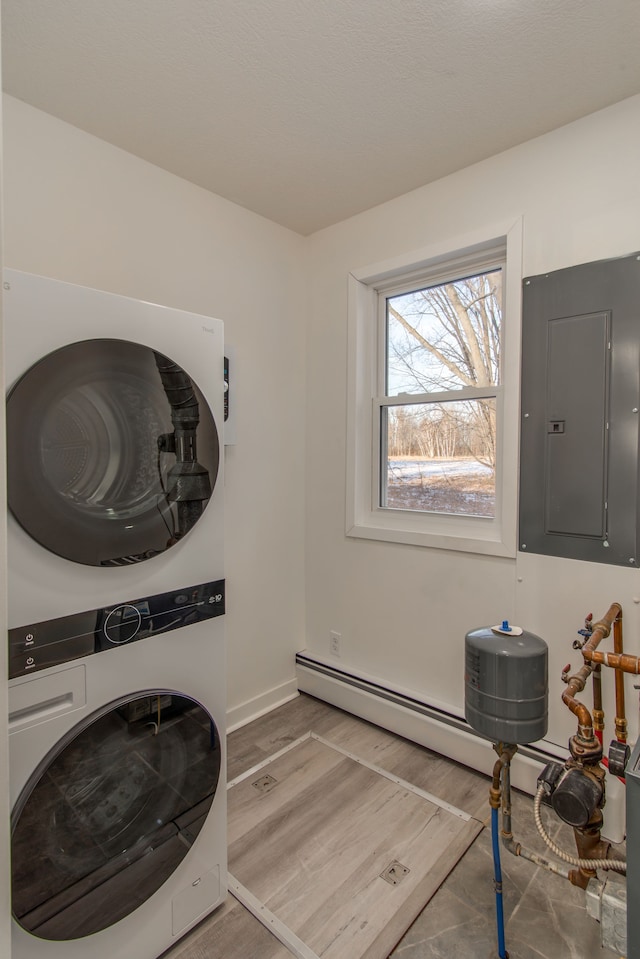 clothes washing area with stacked washer and dryer, hardwood / wood-style floors, and electric panel