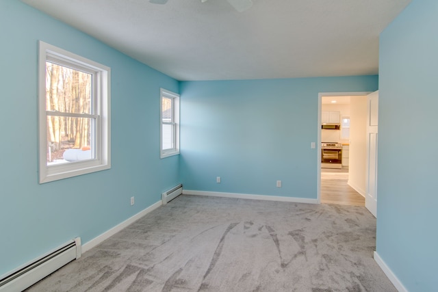 empty room with a baseboard radiator and light colored carpet