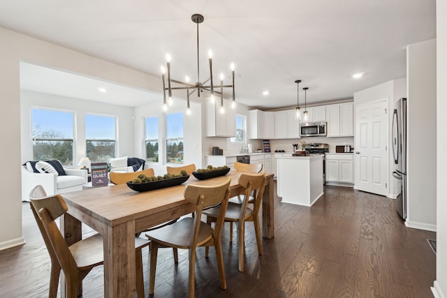 dining space with dark wood-type flooring and an inviting chandelier