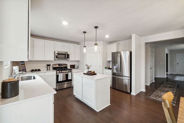 kitchen featuring a kitchen island, decorative light fixtures, white cabinetry, sink, and stainless steel appliances