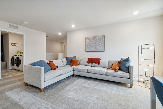 living room featuring light carpet and washer and dryer