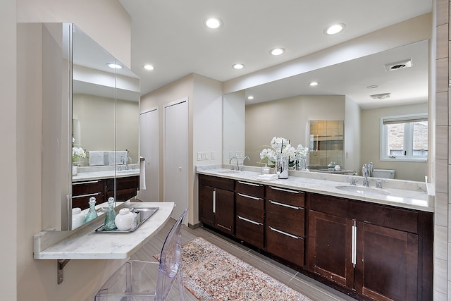 bathroom featuring double vanity, a sink, and recessed lighting