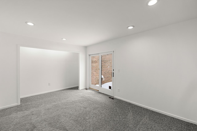 unfurnished room featuring recessed lighting, dark carpet, visible vents, and baseboards