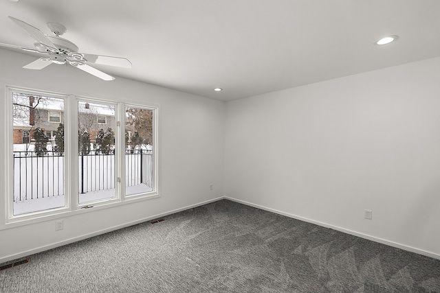 unfurnished room with dark colored carpet, recessed lighting, visible vents, and baseboards