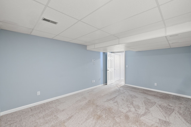 finished below grade area featuring visible vents, carpet floors, a paneled ceiling, and baseboards